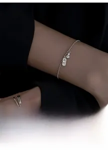 Gros plan d'un bracelet en perles d'argent avec breloque Pingan et zircon brillant