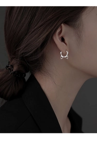 Close-up of minimalist S925 silver cat-shaped hoop earrings worn on a model's ear