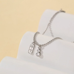 Collier minimaliste argenté avec pendentif Ping'an et zircons sur support ondulé