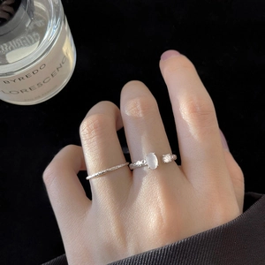 Set di anelli d'argento minimalisti con trama martellata e gemma ovale su mano femminile
