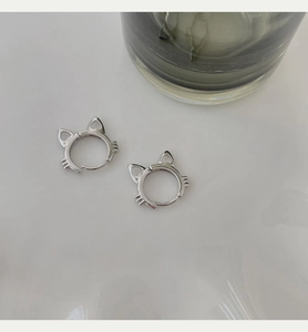 Macro shot of polished S925 silver cat-shaped hoop earrings with cute cat ears and whiskers