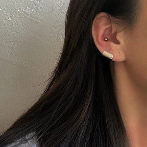 Minimalist silver wide curved ear cuff featuring a polished metallic high-shine finish