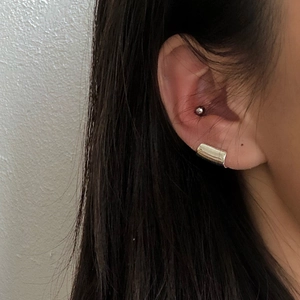 Minimalist silver geometric ear clips with wide rectangular shape and glossy finish