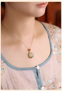 Close-up of a vintage Chinese style Hetian jade pendant with painted floral patterns on neck