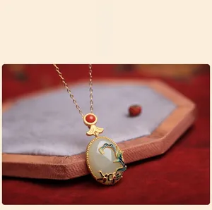 Detailed macro of vintage cloisonné enamel pendant with white jade and red bead