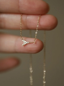 Detailed view of a gold Eiffel Tower pendant necklace with shimmering zircon accents