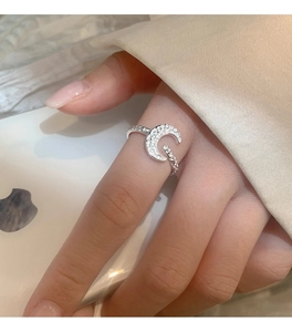 Close-up of textured moon ring with sparkling pavé zircons on woman's hand