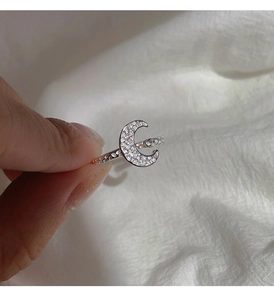 Macro shot of silver crescent moon ring with sparkling zircon inlay and textured band