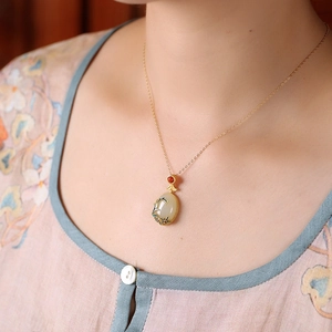 Chinese retro gold necklace with oval green jadeite pendant and bamboo leaf details
