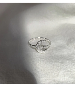 Macro shot of silver crescent moon ring with cubic zirconia inlay and hammered metal texture