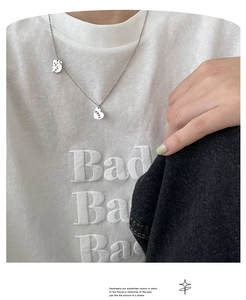 Détail du collier argenté avec pendentifs ours et coeur hope porté par un modèle