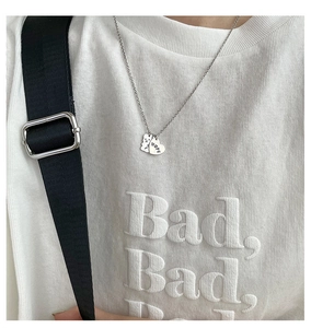 Détail du collier avec pendentif ours et cœur gravé HOPE porté par un mannequin