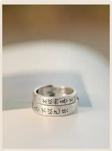 Gros plan de bagues de couple en argent S925 avec finition mate et gravure calligraphique