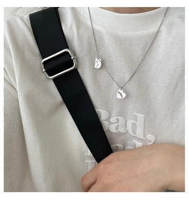 Détail du collier argenté avec pendentifs ours et cœur gravé HOPE sur tenue décontractée