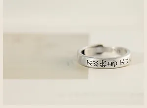Détail macro de bague en argent S925 avec finition brossée et calligraphie chinoise