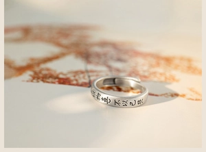 Vue macro d'une bague en argent vintage avec calligraphie gravée et finition mate
