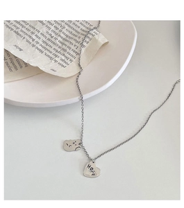 Détail du collier argenté avec pendentif coeur HOPE et breloque visage mignon
