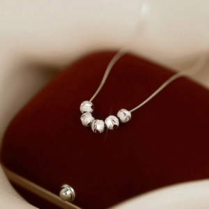 Élégant collier en argent avec cinq perles facettées sur velours rouge, style de luxe