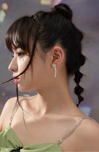 Détail de la boucle d'oreille fleur argentée avec cristal vert et franges sur mannequin