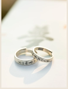 Vue macro de bagues de couple en argent mat avec gravure de calligraphie chinoise
