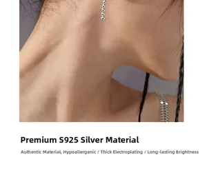 Détail de boucles d'oreilles longue chaîne en argent S925 portées par un mannequin