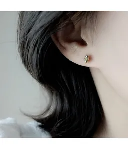 Close-up of olive green marquise-cut crystal stud earring on model's ear