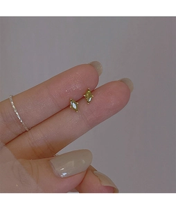 Detailed shot of marquise-cut olive green stud earrings with four-claw setting
