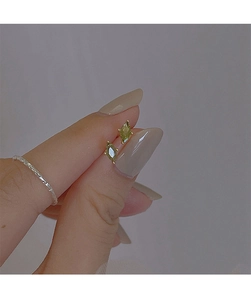 Macro shot of marquise-cut olive green crystal stud earrings on finger