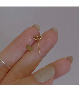 Detailed macro view of olive green marquise crystal stud earrings in gold setting