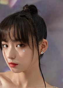 Gros plan d'une boucle d'oreille fleur argentée avec gemme verte sur un mannequin