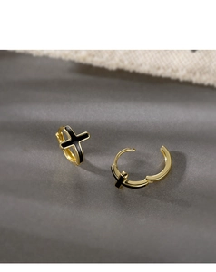 Détails de la fermeture mécanique et du motif croix noire sur créoles dorées