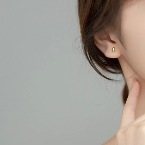 Olive green marquise crystal stud earrings with gold plating on model ear