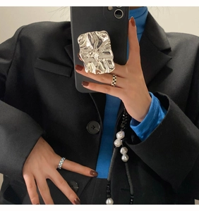 Mirror selfie showing a silver irregular lava phone socket with a checkerboard ring