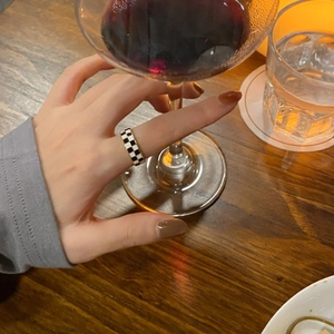 Macro shot of black and white checkerboard ring on a wooden table in a cozy setting