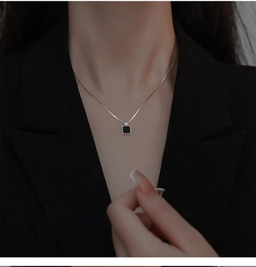 Détail du collier avec pendentif carré noir élégant porté sur un mannequin avec chaîne