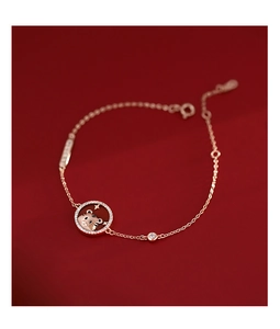Detail of rose gold tiger bracelet with red zodiac pendant and sparkling zircon stones