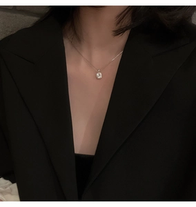 Primo piano della collana con ciondolo in zircone scintillante sul collo di una modella