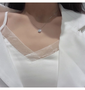 Elegante collana in argento con ciondolo quadrato in zirconia indossata da una modella con luce soffusa