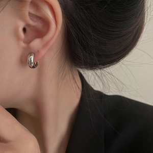 Close-up of minimalist silver hoop ear cuff with high-polished mirror finish on model