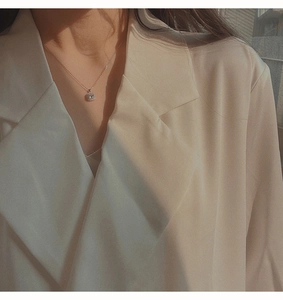 Primo piano di una collana in argento con pendente quadrato in zirconia su un modello