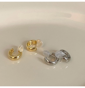 Macro view of gold and silver clip-on earrings with comfortable silicone pads