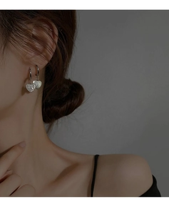 Vue détaillée des boucles d'oreilles cœur vintage avec cristaux et finition argent
