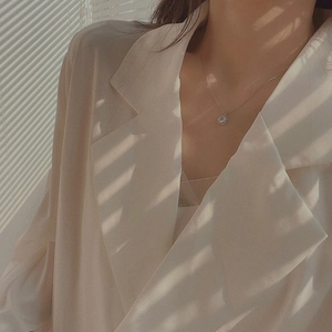 Primo piano di una collana in argento con ciondolo in zircone con luci e ombre eleganti