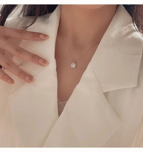 Primo piano di una collana in argento con pendente quadrato in zircone su una modella