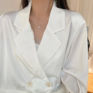 Dettaglio della collana con ciondolo in zircone quadrato con blazer in raso bianco