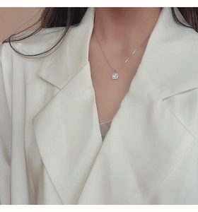 Primo piano di un'elegante collana in argento con ciondolo quadrato in zirconia su una modella