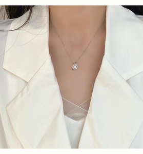 Dettaglio di una collana con ciondolo quadrato in zirconi argento su modella in bianco
