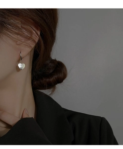 Vue rapprochée de boucles d'oreilles vintage cœur argenté avec texture brossée