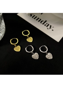 Détail de boucles d'oreilles cœur dorées et argentées avec texture givrée et marque S925