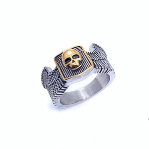 Macro view of a punk skull ring showing gold-plated relief and feather textures